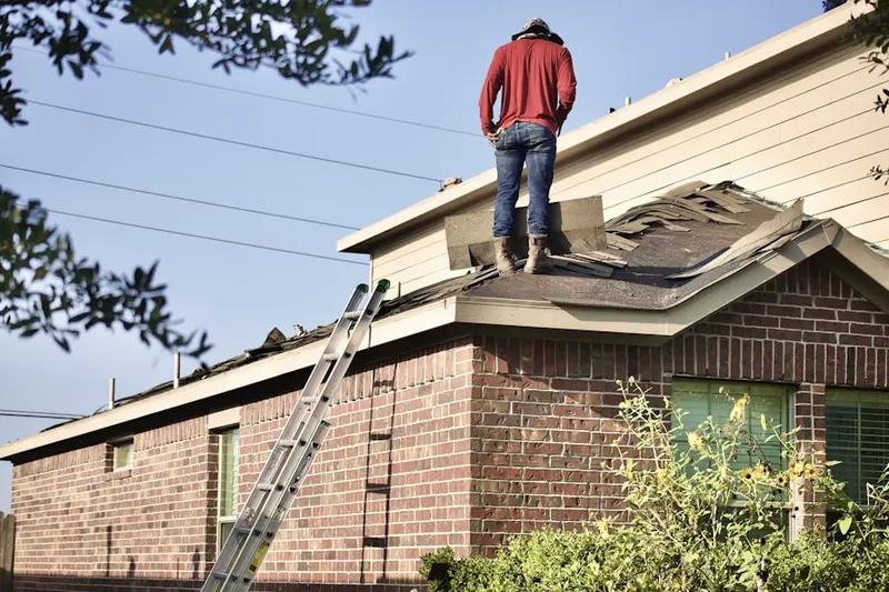 Professional roofer working on a residential roof in Oelwein